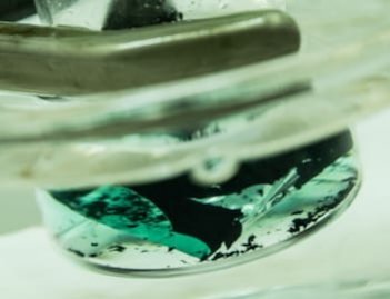 A solution turns green as it pulls cobalt from a spent lithium-ion cathode. A Rice University laboratory is developing an environmentally friendly method to recover valuable metals from used batteries. (Photo by Jeff Fitlow/Rice University)